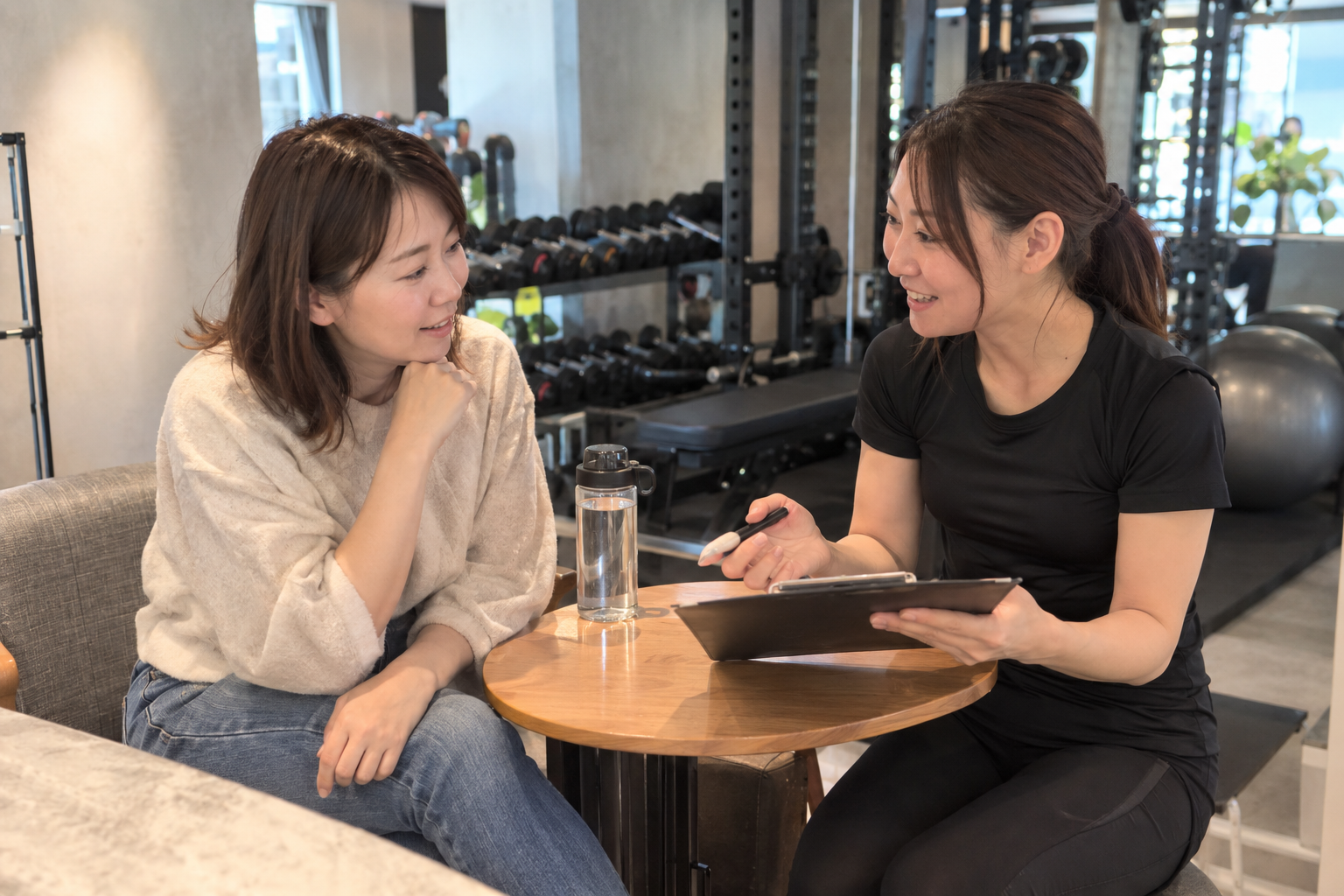 梅田エリアでトレーナーへ相談する女性